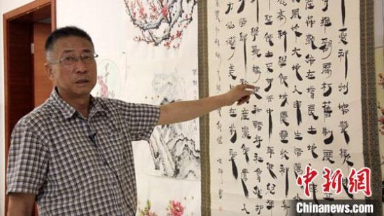 圖為朱群和他的敦煌漢簡(jiǎn)書(shū)體?！「攥?攝