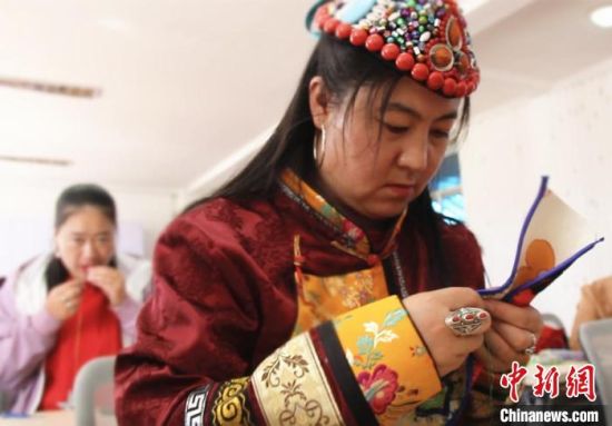 圖為裕固族婦女學(xué)習(xí)刺繡?！∈缝o靜 攝