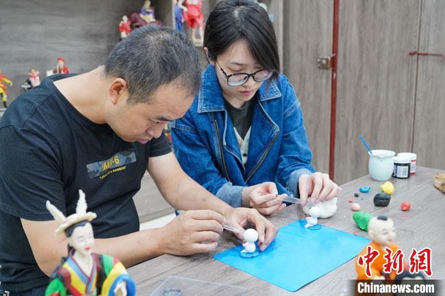 <a target='_blank'  data-cke-saved- >中新社</a>記者(右)現(xiàn)場體驗(yàn)面塑制作過程。　陳爭強(qiáng) 攝