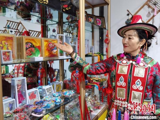 圖為身著民族服飾的隴原巧手展示手工藝品。(資料圖) 徐雪 攝