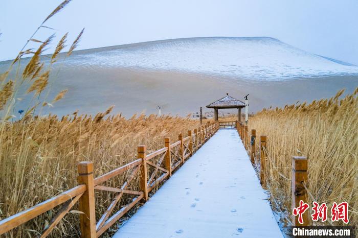 2021年11月28日，在敦煌鳴沙山月牙泉景區(qū)，沙雪交融，更顯北國風(fēng)情?！⊥醣筱y 攝