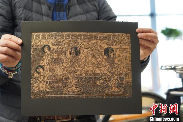 圖為手工書(shū)藝人展示敦煌雕版壁畫(huà)印刷品。　九美旦增 　攝