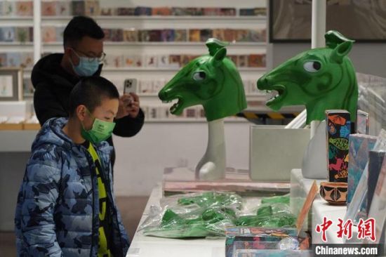 圖為“神馬來(lái)了”銅奔馬頭套吸引參觀者駐足。　九美旦增 攝