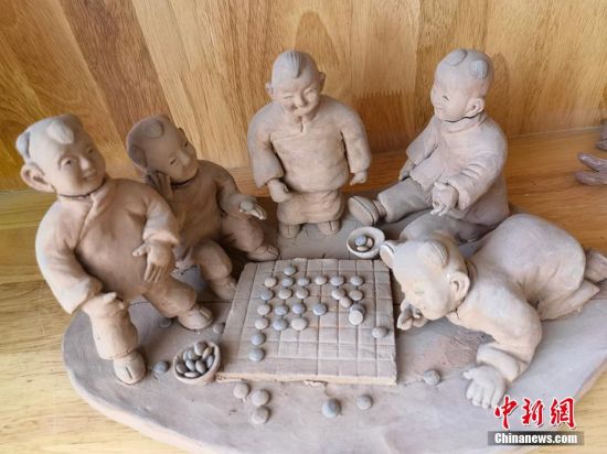 圖為泥塑作品展現(xiàn)下棋場景。 劉玉桃 攝