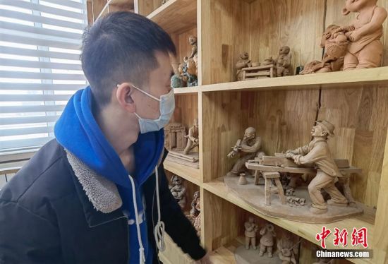 圖為學(xué)生欣賞泥塑作品。 劉玉桃 攝