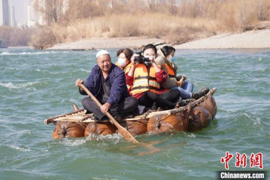 2月24日，年過(guò)七旬的蘭州羊皮筏子制作技藝第三代傳承人張德寶在黃河上劃著羊皮筏子。(資料圖) 九美旦增 攝
