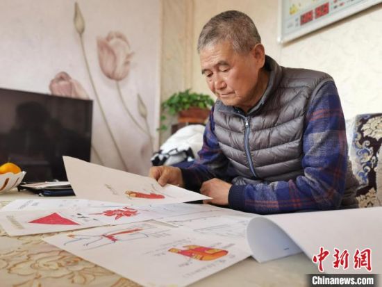 圖為陸鵬飛向記者展示多年帶隊(duì)的手寫筆記?！堟?攝