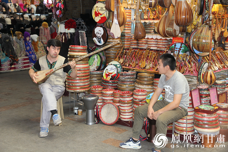 烏魯木齊二道橋巴扎內，店主正在向客人展示樂器。楊文遠 攝