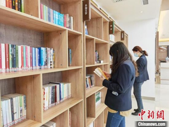 圖為在甘肅公航旅建設(shè)集團(tuán)有限公司的職工書屋，職工挑選書籍?！⌒煅?攝