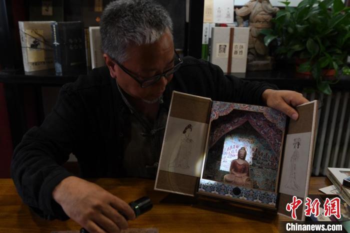 圖為讀者出版集團讀者晉林工作室獨立出品人徐晉林，展示互動性強的敦煌題材手工書。(資料圖) 楊艷敏 攝