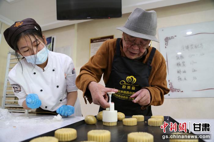 當日，受邀參加活動的臺胞臺屬代表、兩岸婚姻及子女、在甘臺商代表等歡聚一堂。圖為77歲的在甘臺胞潘天鑒制作月餅。九美旦增 攝