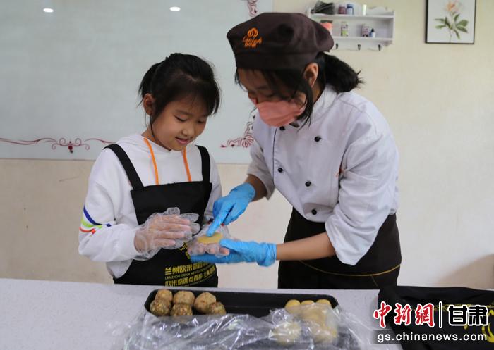 圖為在甘臺胞小朋友在工作人員指導下制作月餅。九美旦增 攝