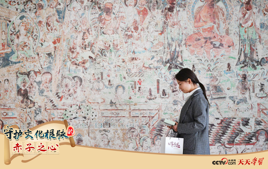 2023年4月25日，敦煌研究院文物數(shù)字化保護(hù)團(tuán)隊創(chuàng)意營銷人員廖雪婷從一幅高保真復(fù)制壁畫前走過。