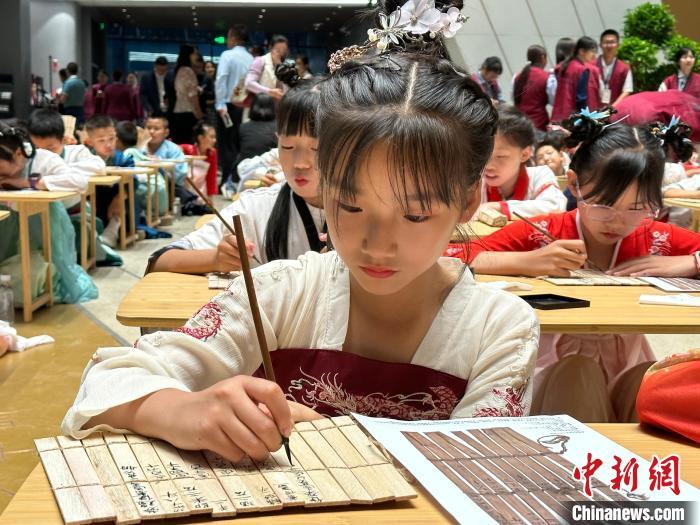 圖為小朋友在甘肅簡(jiǎn)牘博物館練習(xí)書法?！≈行律缬浾?戴文昌 攝
