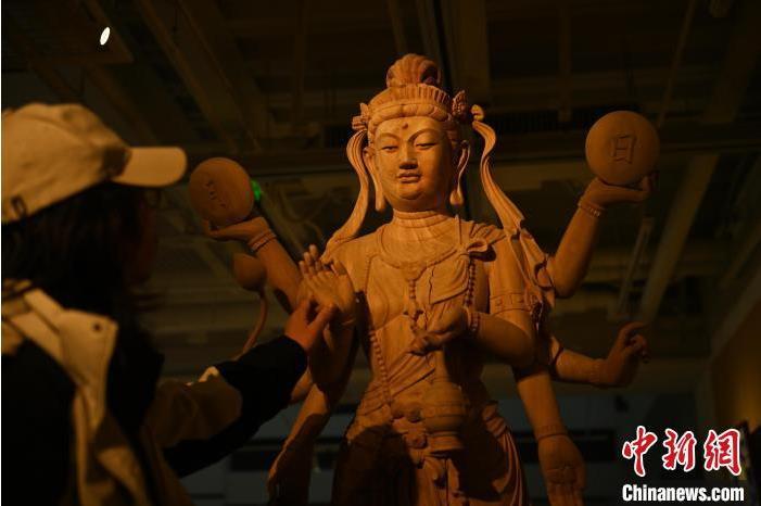圖為季茂杰觀察自己創(chuàng)作的敦煌木雕。李亞龍 攝</p>
<p>