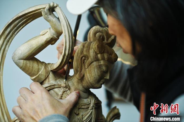圖為季茂杰進(jìn)行敦煌元素的木雕創(chuàng)作。李亞龍 攝</p>
<p>