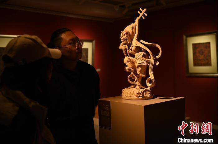 圖為季茂杰向參觀者介紹自己創(chuàng)作敦煌木雕的過程。李亞龍 攝</p>
<p>
