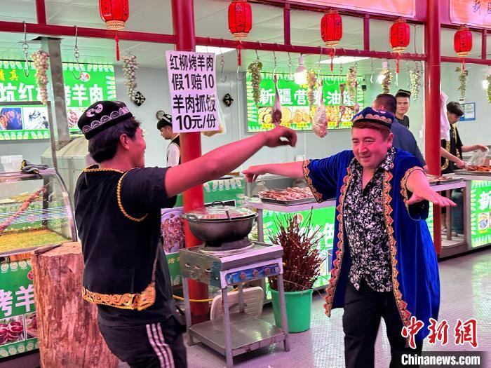圖為餐飲經(jīng)營者在“西涼不夜城”跳起舞蹈引客?！〈魑牟?攝</p><p>