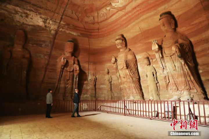 7月15日，游人參觀甘肅省平?jīng)鍪袥艽h百里石窟長廊中的南石窟寺1號(hào)窟。百里石窟長廊位于涇川縣境內(nèi)，由512個(gè)石窟、5眼窟中石井組成，現(xiàn)存王母宮石窟、鳳凰山石窟、南石窟寺、丈八寺石窟、羅漢洞石窟、太山寺石窟等規(guī)模較大的石窟群，還有數(shù)量眾多的小石窟群。南石窟寺開鑿于北魏永平三年，其中1號(hào)窟屬于大型七佛窟，七佛高達(dá)6米。中新社記者 李亞龍 攝